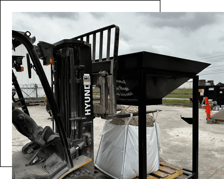 A forklift meticulously transfers soil into a large, white bag beneath a black metal hopper. Nearby, a worker in orange clothing stands by a metal container. This is just another day for a bulk bags supplier in South Texas.