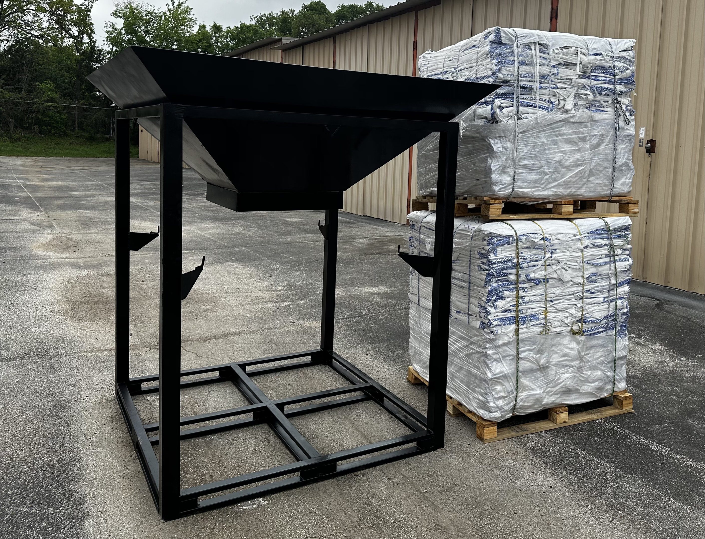 A black metal frame with a large bin on top of it.